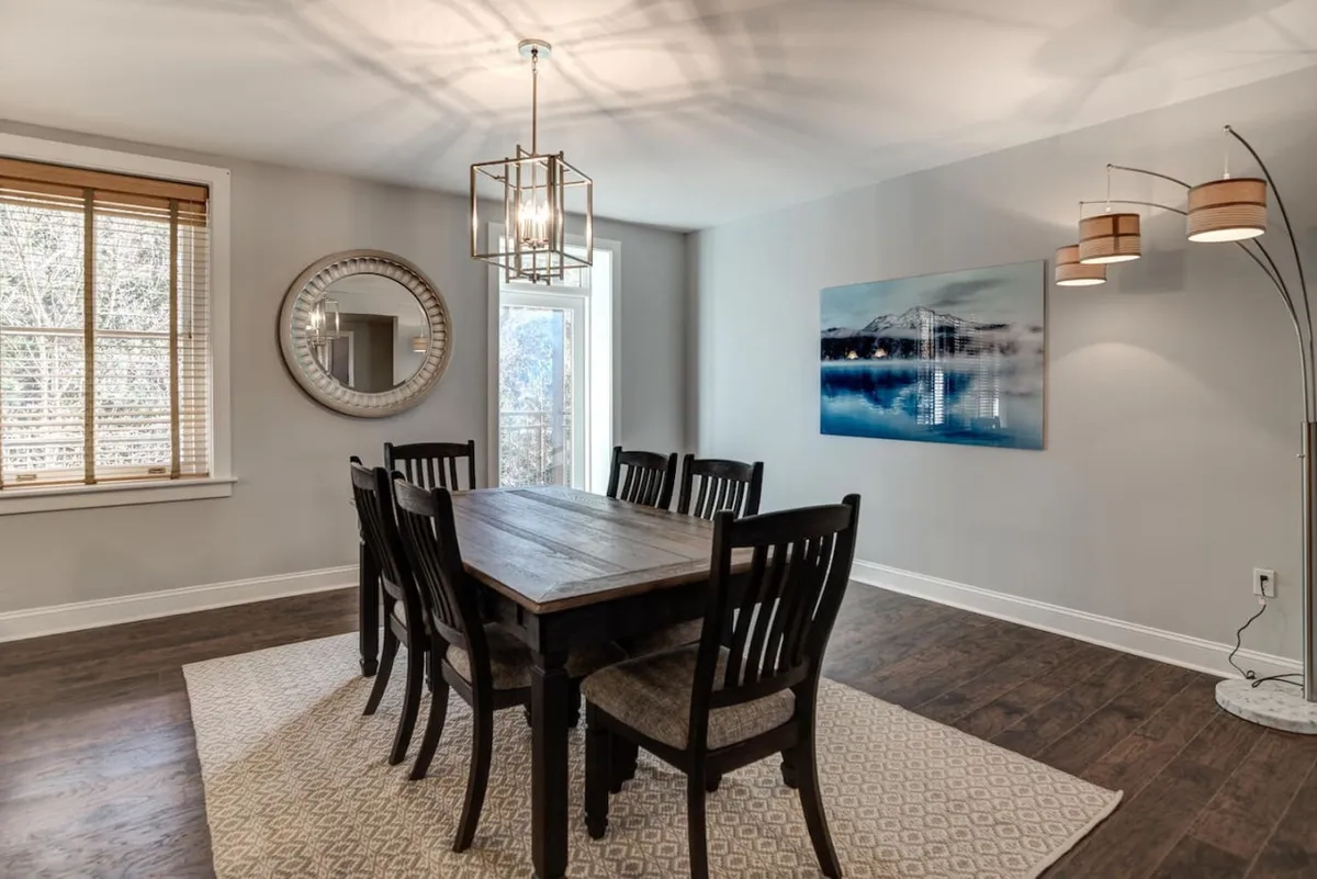 An elegant dining area with a sophisticated table setting, gleaming chandeliers, decorative artwork, and a large mirror reflecting the inviting space. The atmosphere is perfect for intimate dinners or lingering conversations after a day’s adventures.