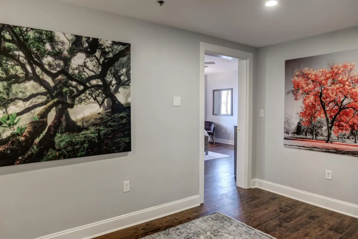 A serene living space with prominent, colorful wall art depicting nature, offering a comfortable area for relaxation and engaging conversation.